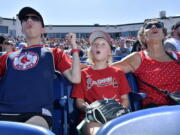 From left, Wyatt Smith, 17, of Waterville, Maine, Tessa Dutil, 9, of Sidney, Maine, and their grandmother Anne Smith, of Watervillle, Maine, react to a hit during the game between the Portland Sea Dogs and the Hartford Yard Goats, Sunday, August 28, 2022, at Hadlock Field in Portland, Maine. Across the northeastern U.S., outdoor businesses are profiting from the unusually dry weather.