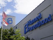 FILE - Missouri and American flags fly outside Planned Parenthood June 24, 2022, in St. Louis. Planned Parenthood, the nation's leading reproductive health care provider and abortion rights advocacy organization, plans to spend a record $50 million ahead of November's midterm elections, pouring money into contests where access to abortion will be on the ballot.