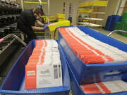 FILE - Vote-by-mail ballots are shown in sorting trays on Aug. 5, 2020, at the King County Elections headquarters in Renton, Wash., south of Seattle. Washington state voters will winnow the field of candidates in dozens of races in the state's primary on Tuesday, Aug. 2, 2022. Washington is a vote-by-mail state, and voters must have their ballots postmarked and in the mail by Tuesday, or they can drop them off at drop boxes by 8 p.m. Under the state's primary system, the top two vote getters advance to the general election in November, regardless of party. (AP Photo/Ted S.