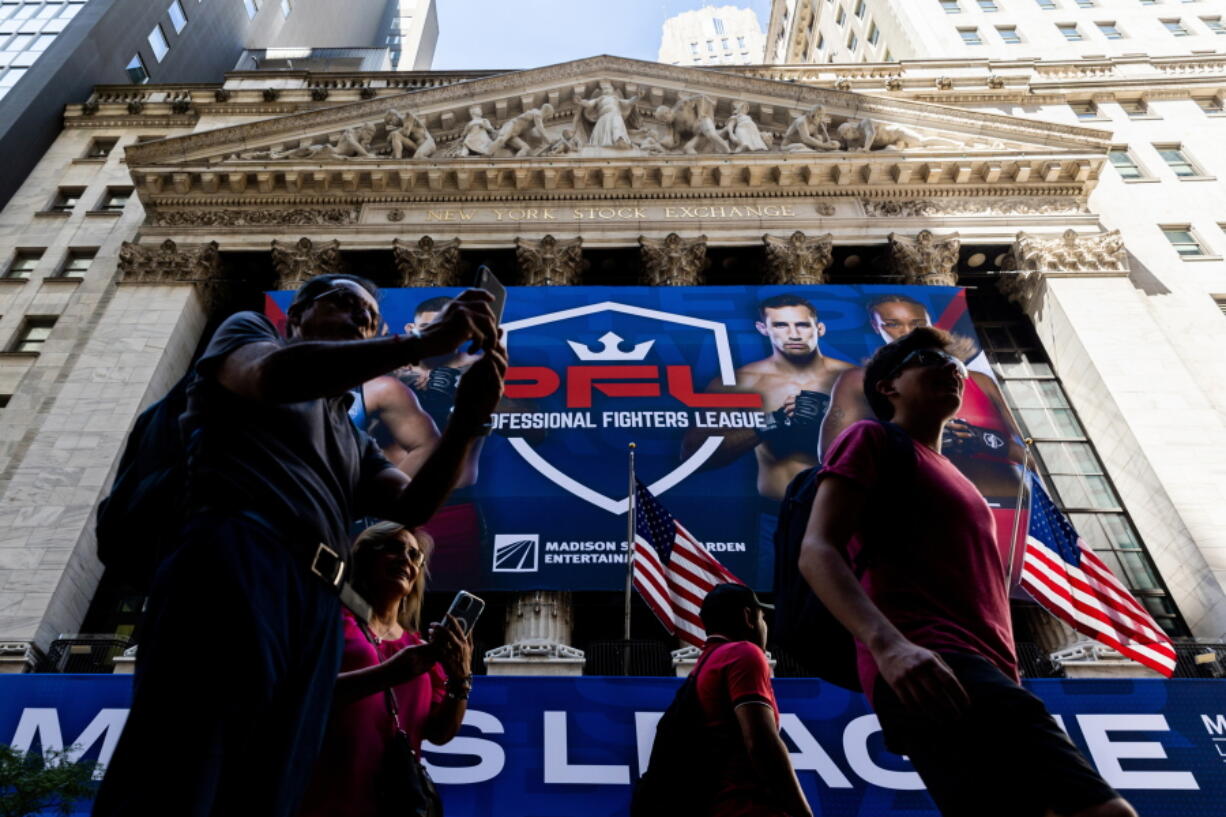 People walk past the New York Stock Exchange, Wednesday, Aug. 3, 2022, in New York.