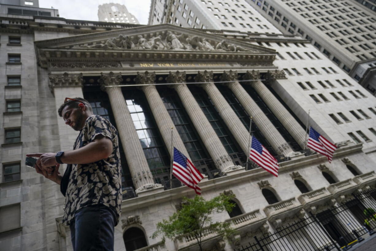 FILE - Pedestrians walk past the New York Stock Exchange, on July 8, 2022, in New York. Stocks are opening higher on Wall Street on Wednesday, Aug. 10, 2022, after the government reported inflation eased slightly last month.