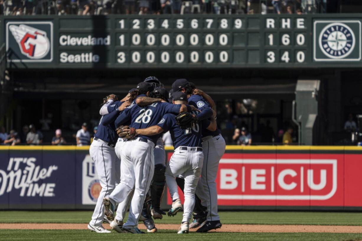 Seattle Mariners infielders, including third baseman Eugenio Suarez (28) and second baseman Adam Frazier, second from, right, celebrate after a baseball game against the Cleveland Guardians, Thursday, Aug. 25, 2022, in Seattle.