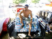 Richard Henry, of Lewiston, sits on stacks of beer cases as he takes a break from loading the beer into a cooler for Saturday's Snake River Rock Festival at the Nez Perce County Fairgrounds in Lewiston, Idaho, on Friday, July 29, 2022. With triple-digit temperatures expected, the festival will be selling $1 water, and have misters and misting tents.