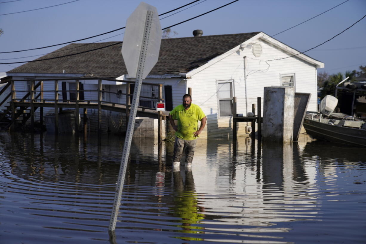 FILE - Nathan Fabre checks on his home and boat destroyed by Hurricane Ida,, Sept. 5, 2021, in Lafitte, La. "We lost everything," said Fabre about the destruction of his home. Federal meteorologists said Thursday, Aug. 4, 2022, this hurricane season may not be quite as busy as they initially thought, but it should still be more active than normal.