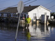 FILE - Nathan Fabre checks on his home and boat destroyed by Hurricane Ida,, Sept. 5, 2021, in Lafitte, La. "We lost everything," said Fabre about the destruction of his home. Federal meteorologists said Thursday, Aug. 4, 2022, this hurricane season may not be quite as busy as they initially thought, but it should still be more active than normal.