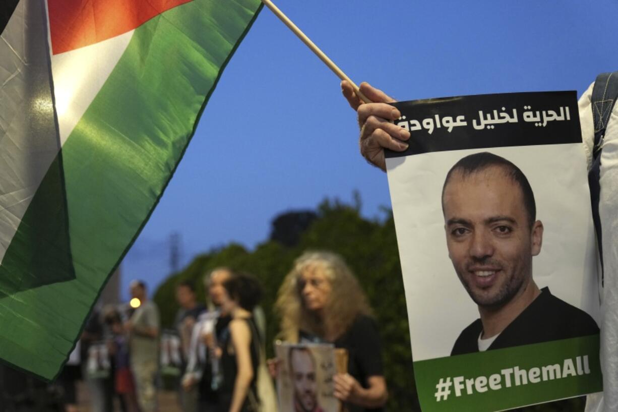 Protesters gather outside the hospital where Khalil Awawdeh, pictured in placards, a Palestinian prisoner in Israel is on hunger strike, in Be'er Yaakov, Aug. 13, 2022. Arabic on the placard: "Freedom for Khalil Awawdeh." Ahlam Haddad, Awawdeh's lawyer, says her client will appeal his case to Israel's Supreme Court as he continues a 165-day hunger strike protesting being held without charge or trial under what Israel refers to as administrative detention. Haddad said his client is in a life-threatening situation. The Islamic Jihad militant group demanded his release as part of an Egyptian-brokered cease-fire to recent fighting in Gaza.