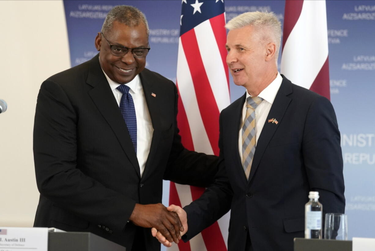 U.S. Secretary of Defense Lloyd Austin, left, and Latvian Minister of Defence Artis Pabriks shake hands during the press conference in Riga, Latvia, Wednesday, Aug. 10, 2022.