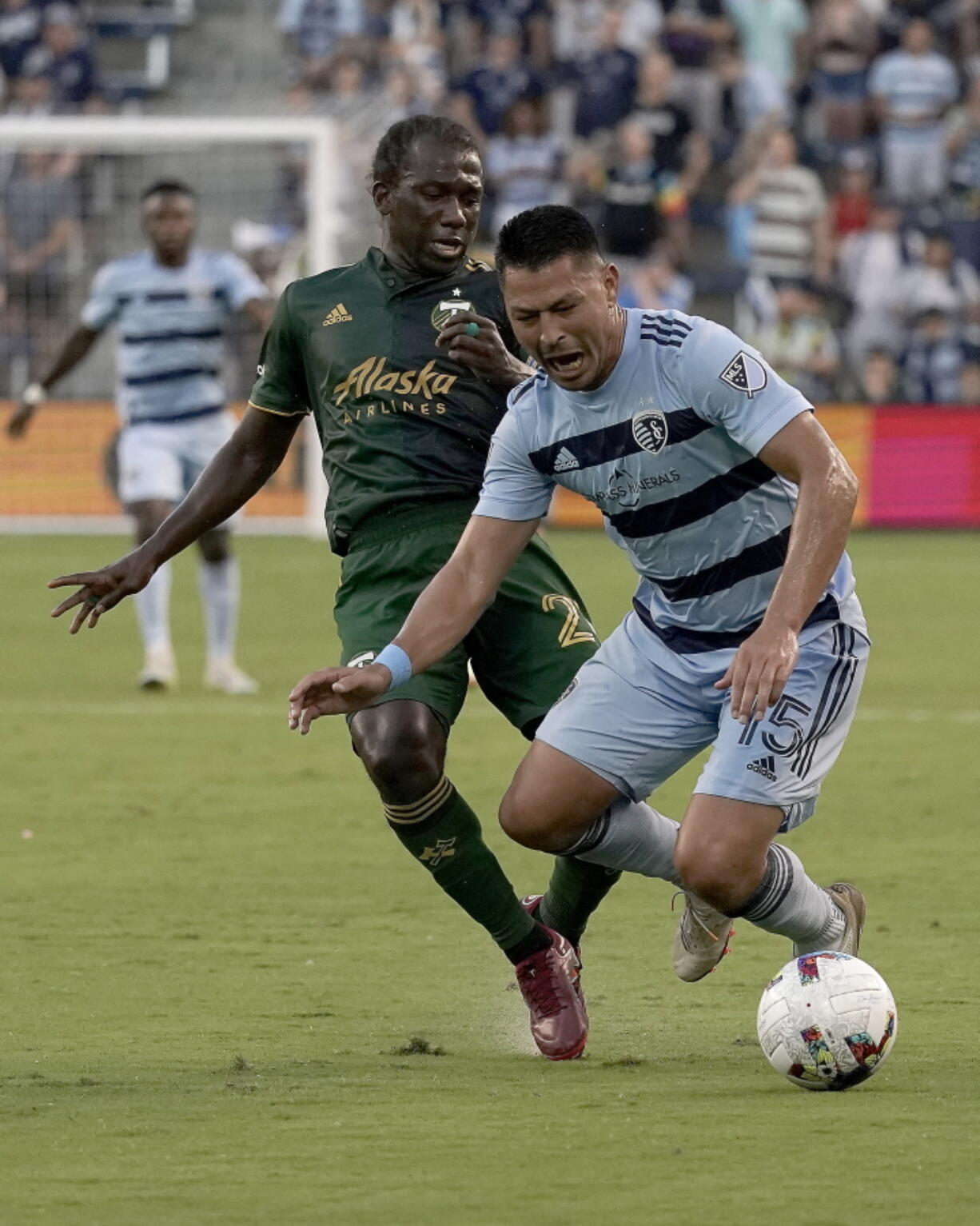 Sporting Kansas City midfielder Roger Espinoza (15) and Portland Timbers midfielder Diego Char? (21) chase the ball during the first half of an MLS soccer match Sunday, Aug. 21, 2022, in Kansas City, Kan.