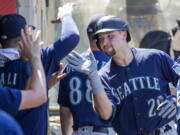 Seattle Mariners' Cal Raleigh celebrates with teammates after hitting a solo home run against the Los Angeles Angels during the fifth inning of a baseball game in Anaheim, Calif., Wednesday, Aug. 17, 2022.