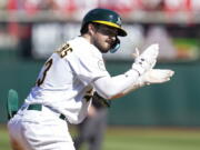 Oakland Athletics' Shea Langeliers celebrates after hitting an RBI-triple against the Seattle Mariners during the eighth inning of a baseball game in Oakland, Calif., Sunday, Aug. 21, 2022. (AP Photo/Godofredo A.