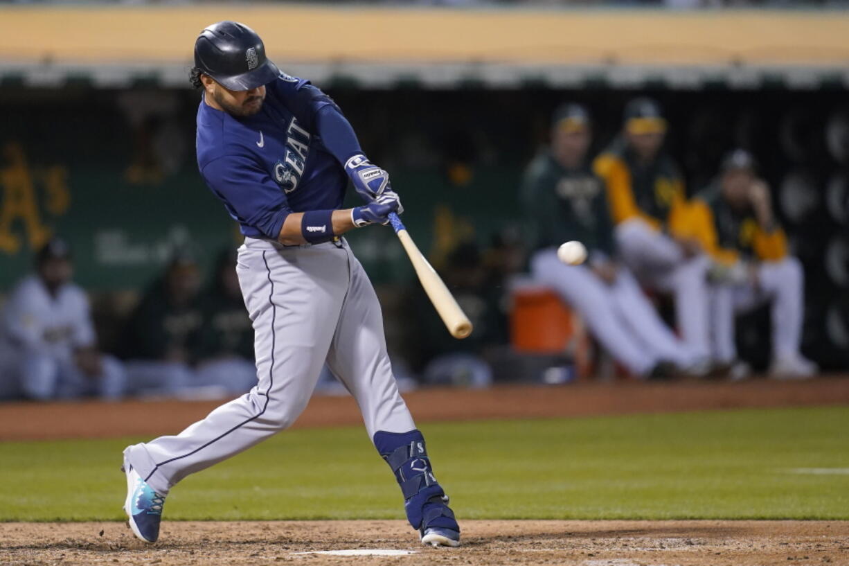 Seattle Mariners' Eugenio Suarez hits a three-run home run against the Oakland Athletics during the sixth inning of a baseball game in Oakland, Calif., Friday, Aug. 19, 2022.