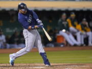 Seattle Mariners' Eugenio Suarez hits a three-run home run against the Oakland Athletics during the sixth inning of a baseball game in Oakland, Calif., Friday, Aug. 19, 2022.