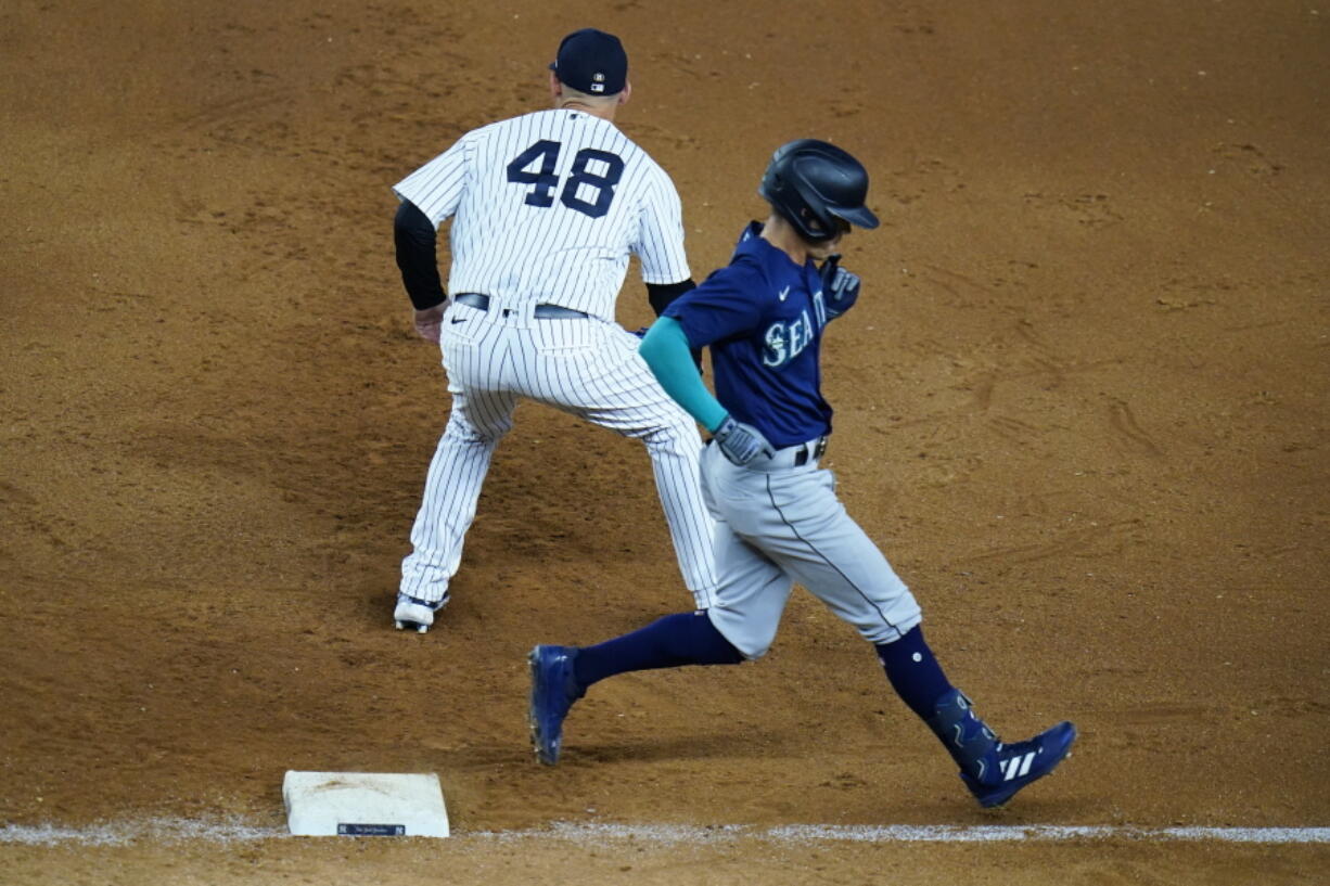 Seattle Mariners' Sam Haggerty, right, runs past New York Yankees' Anthony Rizzo (48) for a single during the ninth inning of a baseball game Tuesday, Aug. 2, 2022, in New York.
