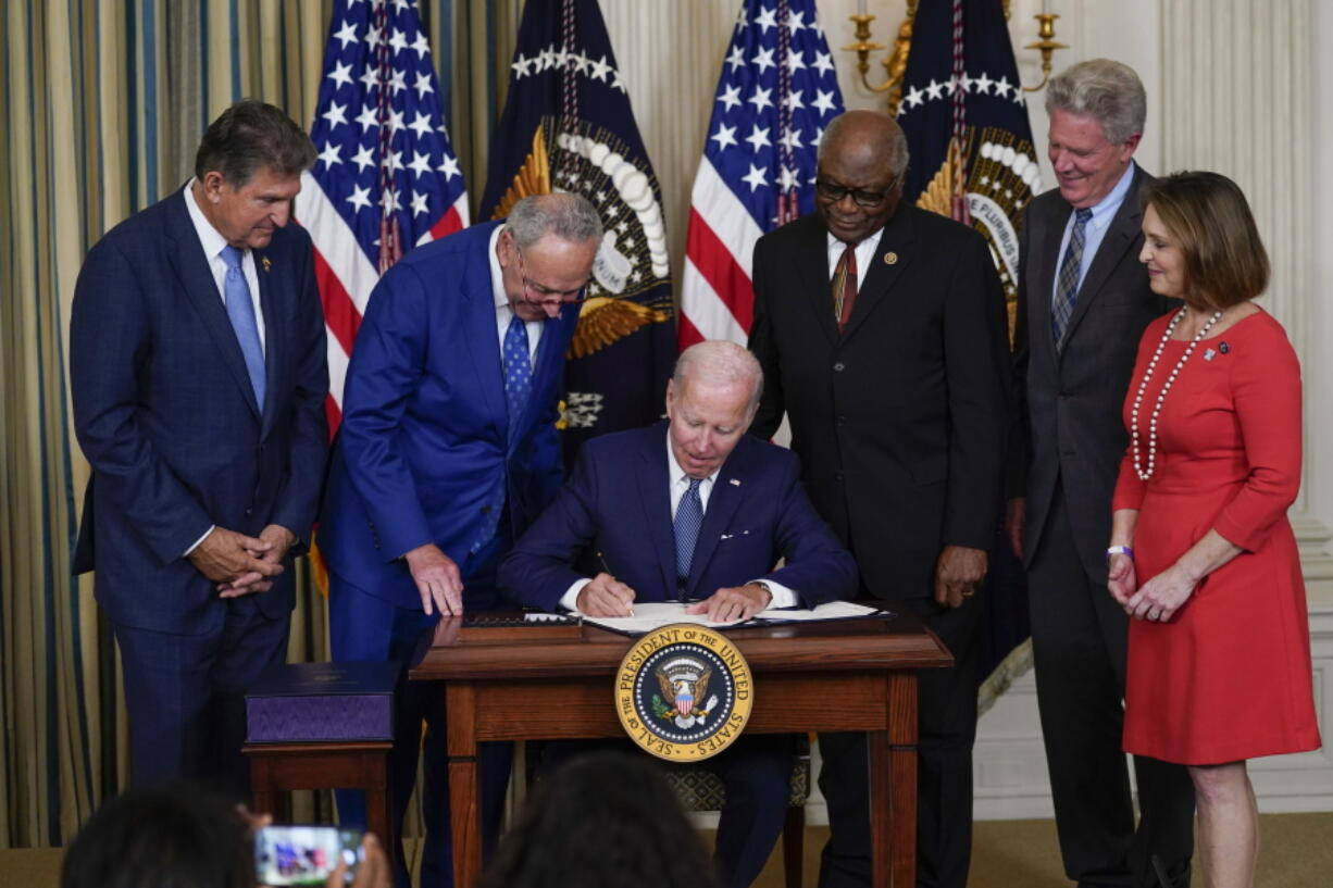 FILE - President Joe Biden signs the Democrats' landmark climate change and health care bill in the State Dining Room of the White House in Washington, Aug. 16, 2022, as from left, Sen. Joe Manchin, D-W.Va., Senate Majority Leader Chuck Schumer of N.Y., House Majority Whip Rep. James Clyburn, D-S.C., Rep. Frank Pallone, D-N.J., and Rep. Kathy Castor, D-Fla., watch. After decades of failed attempts, Democrats passed legislation that aims to reign in the soaring costs of drugs for some Americans.