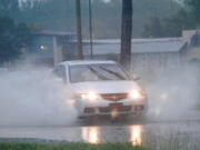 A driver drives through high water on Dale Drive in Marion, Miss., on Wednesday, Aug. 24, 2022. Parts of Mississippi received several inches of rain throughout the day.