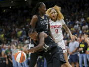 Seattle Storm guard Jewell Loyd (24) gets the rebound and makes a break around Storm center Tina Charles (31) as Washington Mystics center Shakira Austin (0) watches during the first half of Game 1 of a WNBA basketball first-round playoff series Thursday, Aug. 18, 2022, in Seattle.