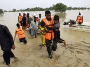 Army troops evacuate people from a flood-hit area in Rajanpur, district of Punjab, Pakistan, Saturday, Aug. 27, 2022. Officials say flash floods triggered by heavy monsoon rains across much of Pakistan have killed nearly 1,000 people and displaced thousands more since mid-June.