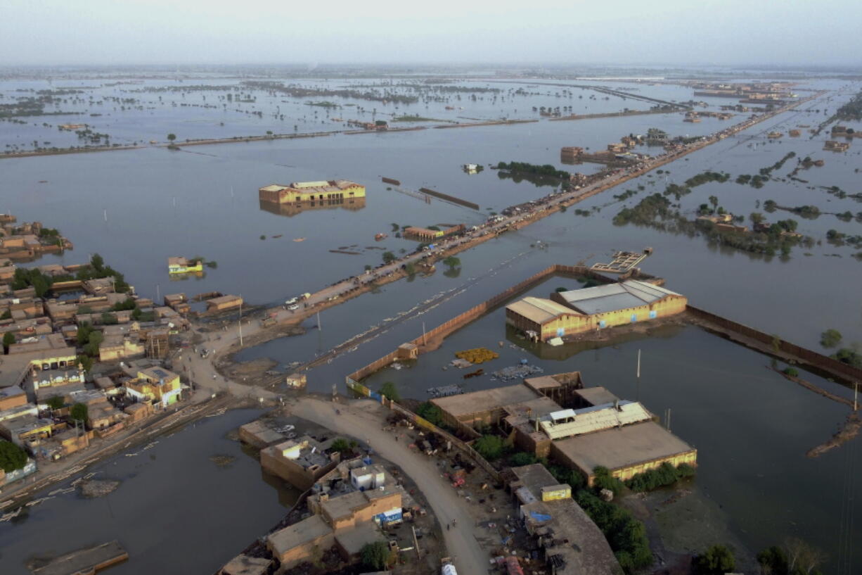 Homes are surrounded by floodwaters in Sohbat Pur city, a district of Pakistan's southwestern Baluchistan province, Monday, Aug. 29, 2022. Disaster officials say nearly a half million people in Pakistan are crowded into camps after losing their homes in widespread flooding caused by unprecedented monsoon rains in recent weeks.