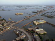 Homes are surrounded by floodwaters in Sohbat Pur city, a district of Pakistan's southwestern Baluchistan province, Monday, Aug. 29, 2022. Disaster officials say nearly a half million people in Pakistan are crowded into camps after losing their homes in widespread flooding caused by unprecedented monsoon rains in recent weeks.