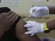 FILE - A man receives the AstraZeneca COVID-19 vaccine at Jabra Hospital in Khartoum, Sudan, Thursday, March 11, 2021.  A new philanthropic project hopes to invest $100 million in up to 10 countries mostly in Africa by 2030 to support up to 200,000 community health workers.