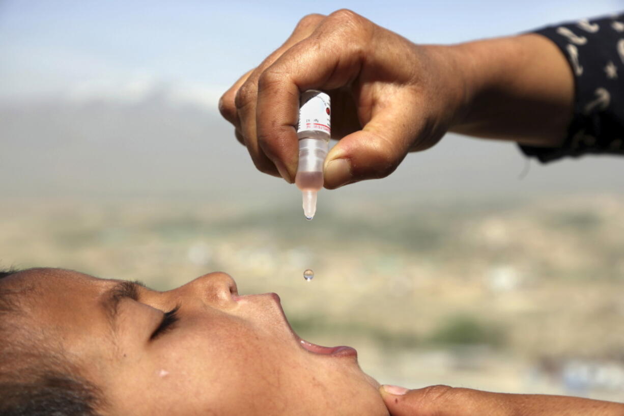 FILE - An Afghan health worker uses an oral polio vaccine on a child as part of a campaign to eliminate polio, on the outskirts of Kabul, Afghanistan, April 18, 2017. For years, global health officials have used billions of drops of an oral vaccine in a remarkably effective campaign aimed at wiping out polio in its last remaining strongholds -- typically, poor, politically unstable corners of the world. Now, in a surprising twist in the decades-long effort to eradicate the virus, authorities in Jerusalem, New York and London have discovered evidence that polio is spreading there. The source of the virus? The oral vaccine itself.