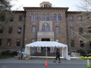 An employee walks near an entrance to Western State Hospital in Lakewood in  2020. A judge has ordered the state agency that operates Washington's largest psychiatric hospital to pay more than $2 million to four female health workers who were assaulted by a violent patient who repeatedly targeted women. (AP Photo/Ted S.