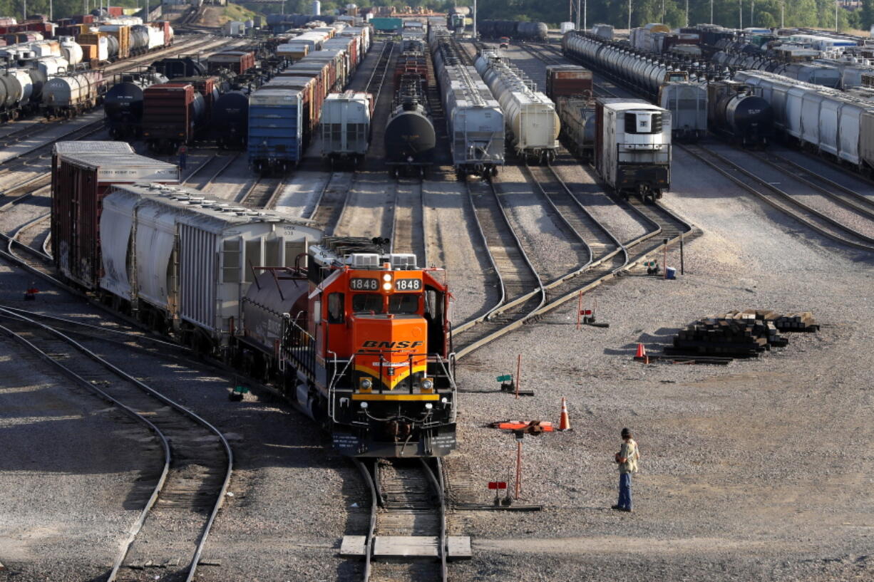 FILE- A BNSF rail terminal worker monitors the departure of a freight train, on June 15, 2021, in Galesburg, Ill. The special board appointed by President Joe Biden to intervene in the stalled railroad contract talks submitted its recommendations to the White House, Tuesday, Aug. 16, 2022, on how to settle the deal that covers 115,000 rail workers and avert a strike, but the details of what those arbitrators suggested weren't immediately available.