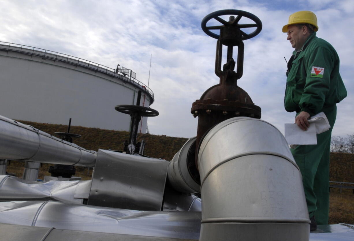 FILE - Istvan Szekeres, engineer of the Hungarian Oil and Gas Company (MOL) checks the receiving area of the Druzhba oil pipeline in the country's largest oil refinery in Szazhalombata, south of Budapest, Hungary, Jan. 9, 2007. Several countries in Europe dependent on Russian energy suffered another blow with confirmation Tuesday, Aug. 9, 2022 that oil shipments have stopped through a critical pipeline. Russian state pipeline operator Transneft said it halted shipments through the southern branch of the Druzhba oil pipeline, which flows through Ukraine to the Czech Republic, Slovakia and Hungary.