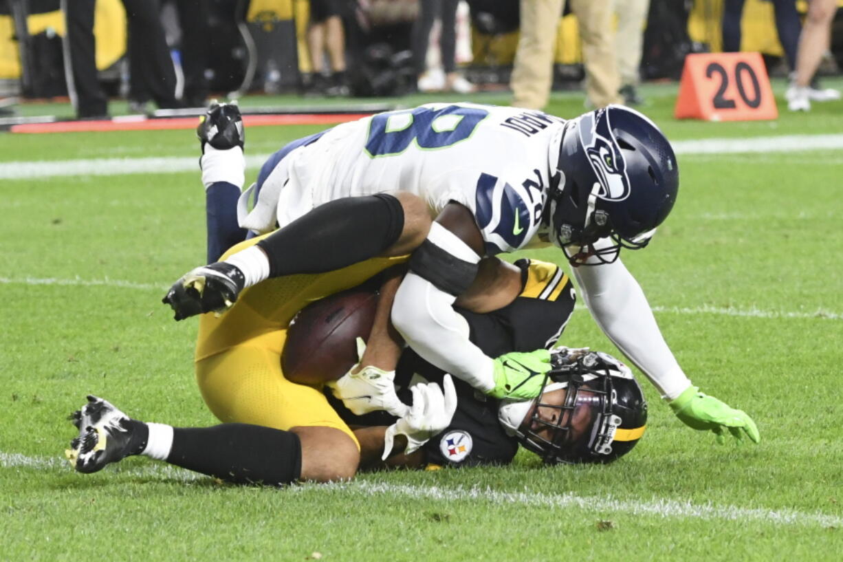 Pittsburgh Steelers tight end Connor Heyward, bottom makes a catch for a two-point conversion as Seattle Seahawks safety Ugo Amadi (28) defends during the second half of a preseason NFL football game, Saturday, Aug. 13, 2022, in Pittsburgh.