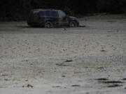 A vehicle is abandoned and surrounded by mud caused by massive flooding on Friday, Aug. 5, 2022, near Haddix, Ky.