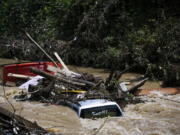 A truck is washed away by floodwaters in the Troublesome Creek near Main Street, in Hindman, Ky., Monday, Aug. 1, 2022. The creek has started to recede, leaving business owners in the town to start cleanup efforts.