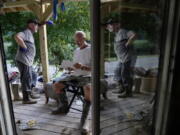 Paul Sparkman, left, and Danny Laferty, stand next to damaged debris on Laferty's front porch on Tuesday, Aug. 2, 2022, in Hindman, Ky., as they clean up debris from massive flooding.