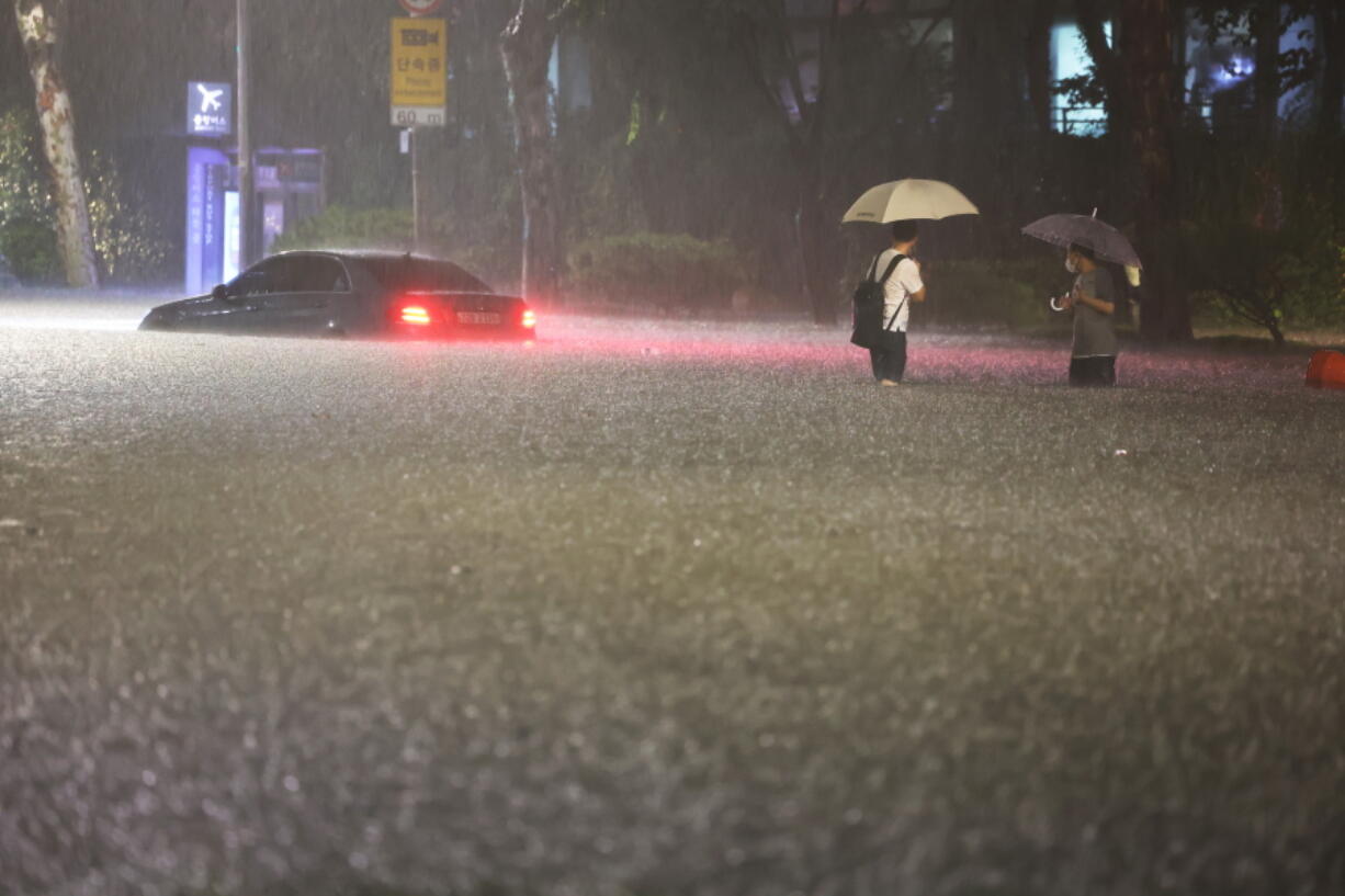 A vehicle is submerged in a flooded road in Seoul, Monday, Aug. 8, 2022. Heavy rains drenched South Korea's capital region, turning the streets of Seoul's affluent Gangnam district into a river, leaving submerged vehicles and overwhelming public transport systems.