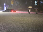 A vehicle is submerged in a flooded road in Seoul, Monday, Aug. 8, 2022. Heavy rains drenched South Korea's capital region, turning the streets of Seoul's affluent Gangnam district into a river, leaving submerged vehicles and overwhelming public transport systems.