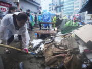 A woman cleans up debris after the water drained from a submerged traditional market following heavy rainfall in Seoul, South Korea, Tuesday, Aug. 9, 2022. Heavy rains drenched South Korea's capital region, turning the streets of Seoul's affluent Gangnam district into a river, leaving submerged vehicles and overwhelming public transport systems.