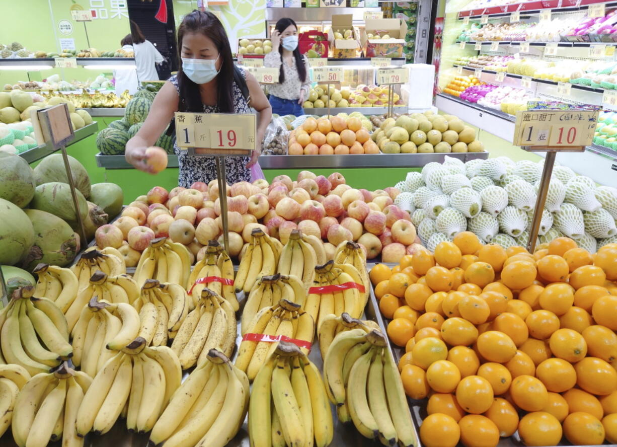 FILE - Customers buy fruit at a stall in Taipei, Taiwan, Sept. 20, 2021. China has blocked imports of citrus and fish from Taiwan in retaliation for a visit to the self-ruled island by a top American lawmaker but avoided sanctions on Taiwanese processor chips for Chinese assemblers of smartphones and other electronics, a step that would send shockwaves through the global economy.