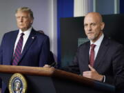 FILE - President Donald Trump listens as Dr. Stephen Hahn, commissioner of the U.S. Food and Drug Administration, speaks during a media briefing in the James Brady Briefing Room of the White House, Aug. 23, 2020, in Washington. Officials in the Trump White House tried to pressure U.S. health experts into reauthorizing a discredited COVID-19 treatment, according to a congressional investigation that provides new evidence of that administration's efforts to override Food and Drug Administration decisions early in the pandemic.