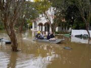 FILE - People paddle through a flooded street at Windsor on the outskirts of Sydney, Australia, July 5, 2022. The U.N. weather agency is predicting the phenomenon known as La Nina is poised to last through the end of this year, a mysterious "triple dip" -- the first this century -- caused by three straight years of its effect on climate patterns like drought and flooding worldwide.