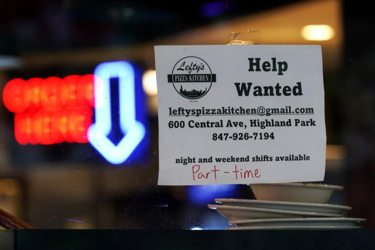 Hiring sign is displayed at a restaurant in Highland Park, Ill., Thursday, July 14, 2022.   The number of Americans applying for unemployment benefits last week rose to its highest level in more than eight months, a sign the labor market may be showing some weakness. Applications for jobless aid for the week ending July 16 rose by 7,000 to 251,000, up from the previous week's 244,000, the Labor Department reported Thursday, July 21.  (AP Photo/Nam Y.