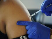 FILE - A Jackson, Miss., resident receives a Pfizer booster shot from a nurse at a vaccination site Tuesday, Feb. 8, 2022. In August 2022, Pfizer and Moderna both asked U.S. regulators to authorize modified versions of their booster vaccine -- shots that are half the original recipe and half protection against BA.4 and BA.5, the newest subtypes of the coronavirus omicron variant. (AP Photo/Rogelio V.