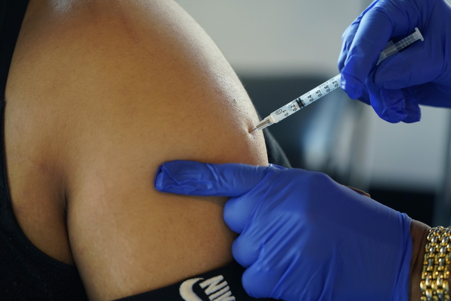 FILE - A Jackson, Miss., resident receives a Pfizer booster shot from a nurse at a vaccination site Tuesday, Feb. 8, 2022. In August 2022, Pfizer and Moderna both asked U.S. regulators to authorize modified versions of their booster vaccine -- shots that are half the original recipe and half protection against BA.4 and BA.5, the newest subtypes of the coronavirus omicron variant. (AP Photo/Rogelio V.