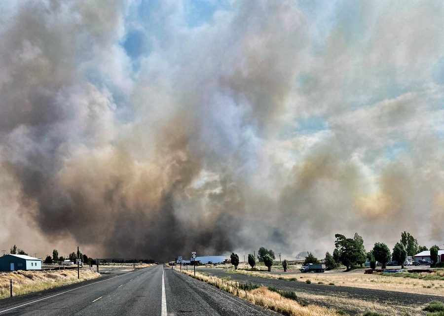 This photo provided by the Washington State Department of Transportation shows smoke from a wildfire burning south of Lind, Wash. on Thursday, Aug. 4, 2022. Sheriff's officials are telling residents in the town of Lind in eastern Washington to evacuate because of a growing wildfire south of town that was burning homes.