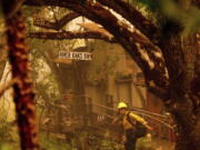 A firefighter battling the McKinney Fire protects a cabin in Klamath National Forest, Calif., on Sunday, July 31, 2022.