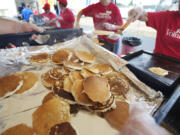 Fred Meyer volunteers cook and serve thousands of pancakes during the annual free pancake breakfast on opening day of the Clark County Fair.