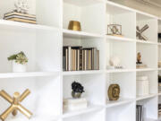 A minimal color palette of black and white, paired with brass accents, creates appealing decor vignettes on this bookcase.