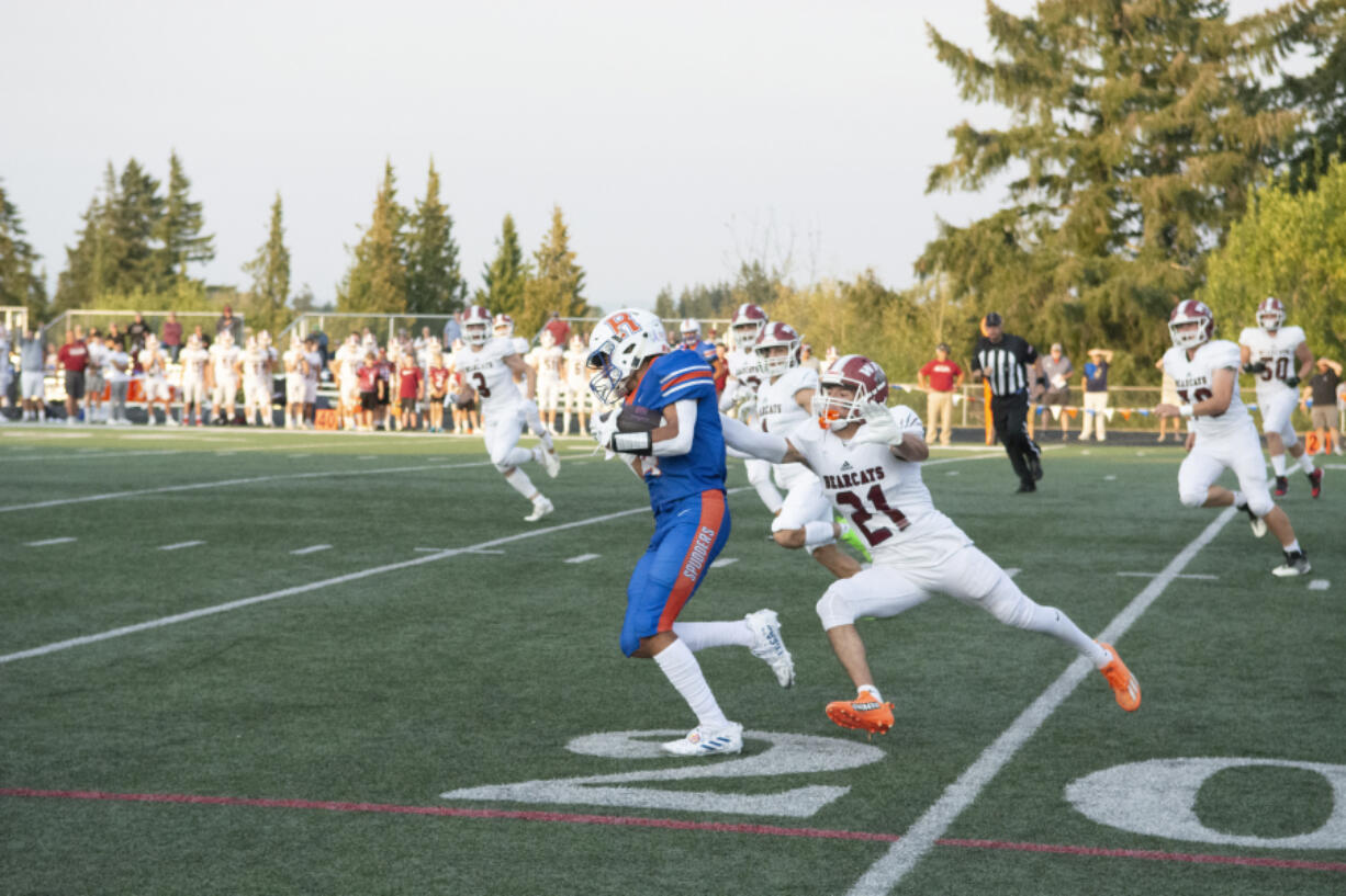 Ridgefield receiver Carter Ferber eludes a defender during a 67-yard catch in the first quarter against W.F. West on Friday. Spet. 2, 2022 at Ridgefield High School.