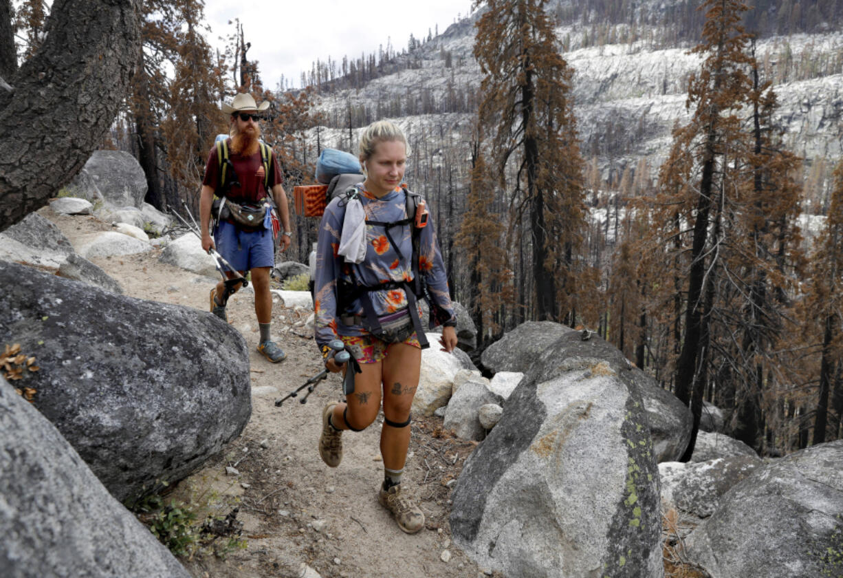 Amanda Williams, center, and Bladen Estes hike along the Pacific Crest Trail and Tahoe Rim Trail near Echo Summit in Eldorado County, California, on Tuesday, Aug. 9, 2022. They???re hiking the entire Pacific Crest Trail. The area is recovering from the 2021 Caldor fire.
