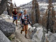 Amanda Williams, center, and Bladen Estes hike along the Pacific Crest Trail and Tahoe Rim Trail near Echo Summit in Eldorado County, California, on Tuesday, Aug. 9, 2022. They???re hiking the entire Pacific Crest Trail. The area is recovering from the 2021 Caldor fire.