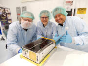 Wesley Faler, Don Smith and Alex Wingeier with the miniature satellite known as a CubeSat that they built. It aboard NASA's Artemis 1 when it lifted off on Saturday and will propel itself into deep space.