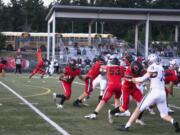 Camas running back Titan Brody (32) looks for an opening after receiving a handoff from quarterback Taylor Ioane (14) against Glacier Peak on Friday at Doc Harris Stadium in Camas (Will Denner/The Columbian)